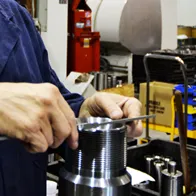 Machinist measuring a precision-turned steel component