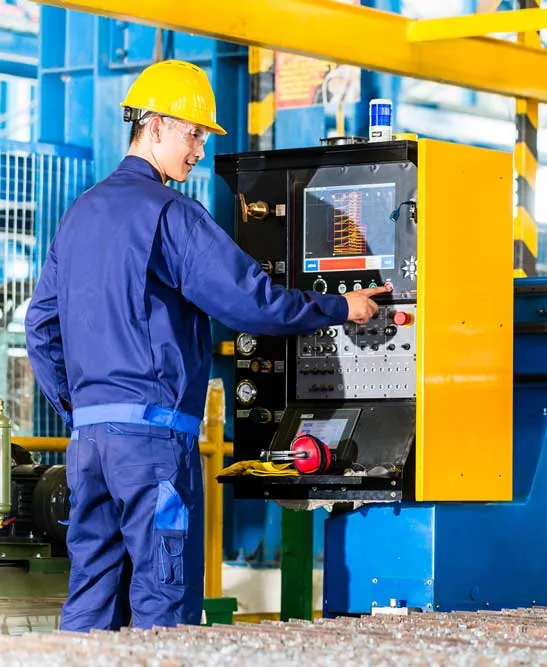 Machinist operating a CNC control panel